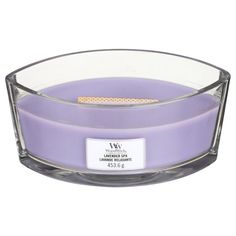 a purple candle with a white label on the top and bottom, in a clear glass bowl