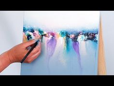 someone is painting on a canvas with watercolors