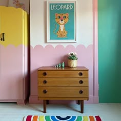 a room with a dresser, rug and painting on the wall above it that says leopard