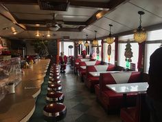 the interior of a restaurant with red and white booths