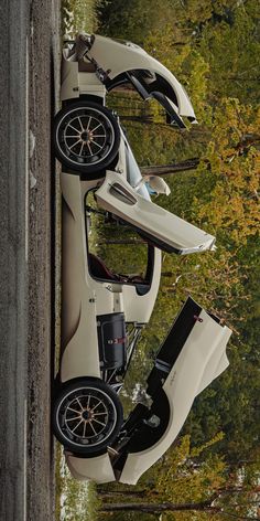 two cars parked next to each other in front of trees