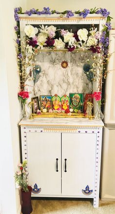 a white cabinet with flowers and pictures on it