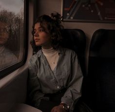 a woman sitting on a train looking out the window