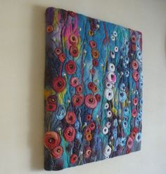 a painting hanging on the wall with buttons and flowers painted on it's surface