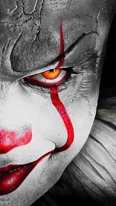 a close up of a clown's face with red eyes