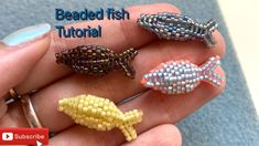 four beaded fish pins sitting on top of each other in someone's hand