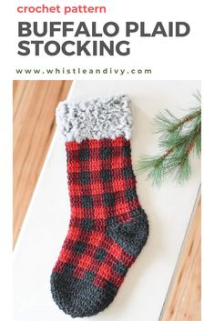 a red and black plaid stocking sitting on top of a white table next to a pine tree