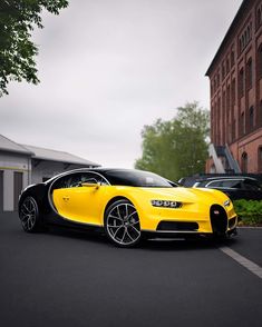 a yellow bugatti parked in front of a building