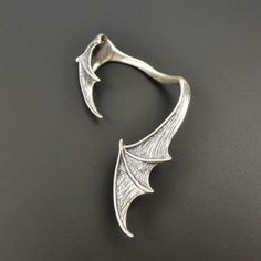 SINGLE LEFT SIDE large vampire bat wing ear climber! Fantastic design with amazing details! Handmade from solid sterling silver. The surface is slightly brushed and oxidized to create depth and texture. Gothic Winged Jewelry For Gifts, Gothic Winged Jewelry Gift, Fantasy Winged Jewelry Gift, Halloween Claw-shaped Jewelry Gift, Halloween Jewelry Gift With Claw Shape, Halloween Gift Jewelry With Claw Shape, Fantasy Metal Ear Cuff For Gift, Silver Fantasy Style Ear Cuff For Gift, Silver Fantasy Style Ear Cuff As Gift