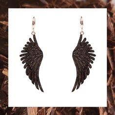 an image of earrings with black feathers on them and the words angel wings written in gold