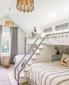 a bedroom with bunk beds and stairs leading up to the second floor, in white painted wood