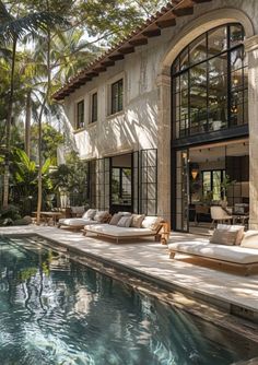 an outdoor swimming pool next to a large house