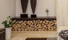 a living room filled with furniture and firewood stacked on top of eachother