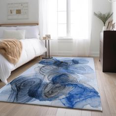 a blue and white area rug with an elephant design on the floor next to a bed