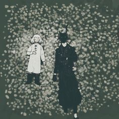 two people standing next to each other in the middle of a field with white flowers