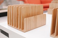 several wooden business cards and holders on a white table in front of an orange chair