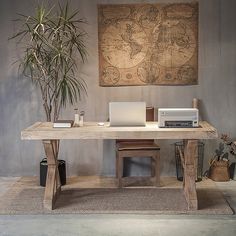 a desk with a laptop and a printer on it in front of a large map