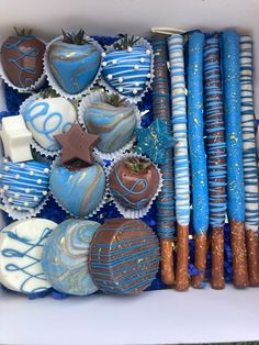 a box filled with lots of blue and white cupcakes