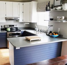 a modern kitchen with stainless steel appliances and blue counter tops, along with wooden flooring