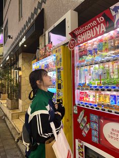 a woman standing in front of a vending machine