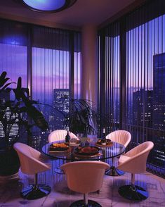 a dining room table with four chairs and a view of the city at night in the background