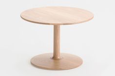 a small round wooden table on a white background