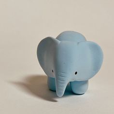 an elephant figurine sitting on top of a white table next to a wall