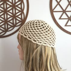 a woman's head wearing a crochet hat in front of two circles