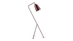 a red floor lamp with a metal base and a wooden shade on the top, against a white background