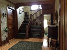 an entry way with stairs and rugs on the floor