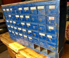 several blue mailboxes are stacked on top of each other in a storage area