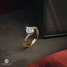 a diamond ring sitting on top of a red velvet couch next to a black box