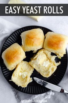 easy yeast rolls on a black plate with butter knife and napkin in the background text overlay says easy yeast rolls