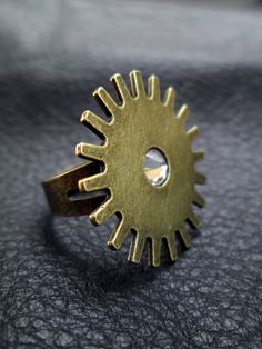 "An industrial or steam-punk antique brass tone cogwheel (gear) cocktail ring with a Swarovski crystal Rhinestone. Sassy and beautiful. The ring base is adjustable. SIZE: The ring will fit US ring sizes 6 and up. MEASUREMENTS: The ring top is 1\" (2.5 cm) in diameter The ring with a red cabochon featured in the last 2 pictures is listed here: https://www.etsy.com/listing/187190206" Ring Industrial, Gear Ring, Wire Crochet Jewelry, Crocheted Jewelry, Steam Punk Jewelry, Industrial Steampunk, Punk Jewelry, Jewelry Boards, Flagstaff