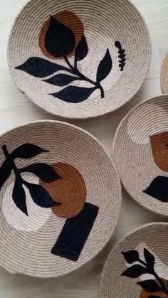 four woven baskets with black and orange designs on them