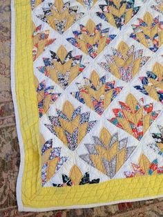 a yellow and white quilt with flowers on it