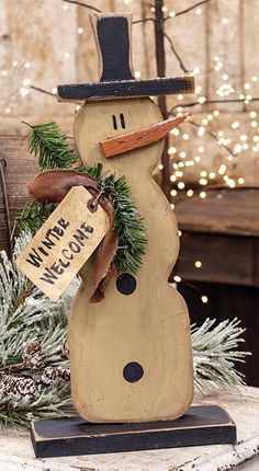 a wooden snowman sitting on top of a table