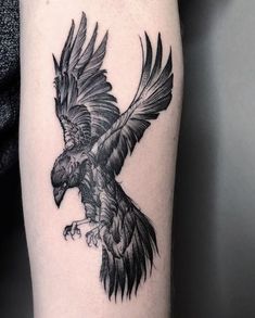 a black and white bird tattoo on the arm