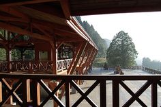 there is a view from the balcony of a wooden building with people walking on it