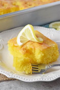 a lemon cake on a plate with a fork in the foreground and text overlay that reads easy & delicious lemon cake