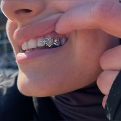 a close up of a person holding a toothbrush to their mouth with two hearts on it