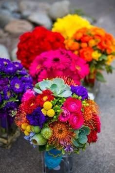 colorful bouquets of flowers are lined up on the ground in front of each other