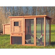 a chicken coop in the middle of a grassy field