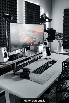 there is a computer on the desk with headphones and speakers in front of it