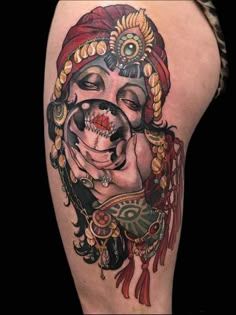 a woman's thigh with an artistic tattoo design on her leg and the face of a