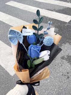 a bouquet of flowers sitting on the side of a road next to a crosswalk