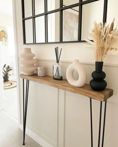 a wooden table topped with vases and mirrors