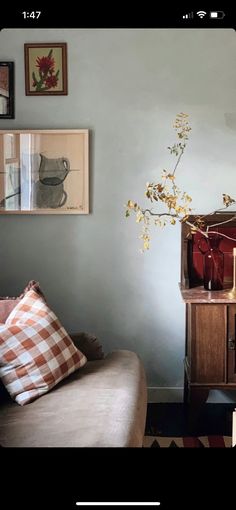 a living room filled with furniture and pictures on the wall next to a couch in front of a window