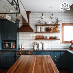 a kitchen with blue cabinets and wooden counter tops