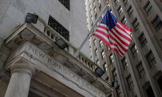 an american flag flying in front of the new york stock exchange